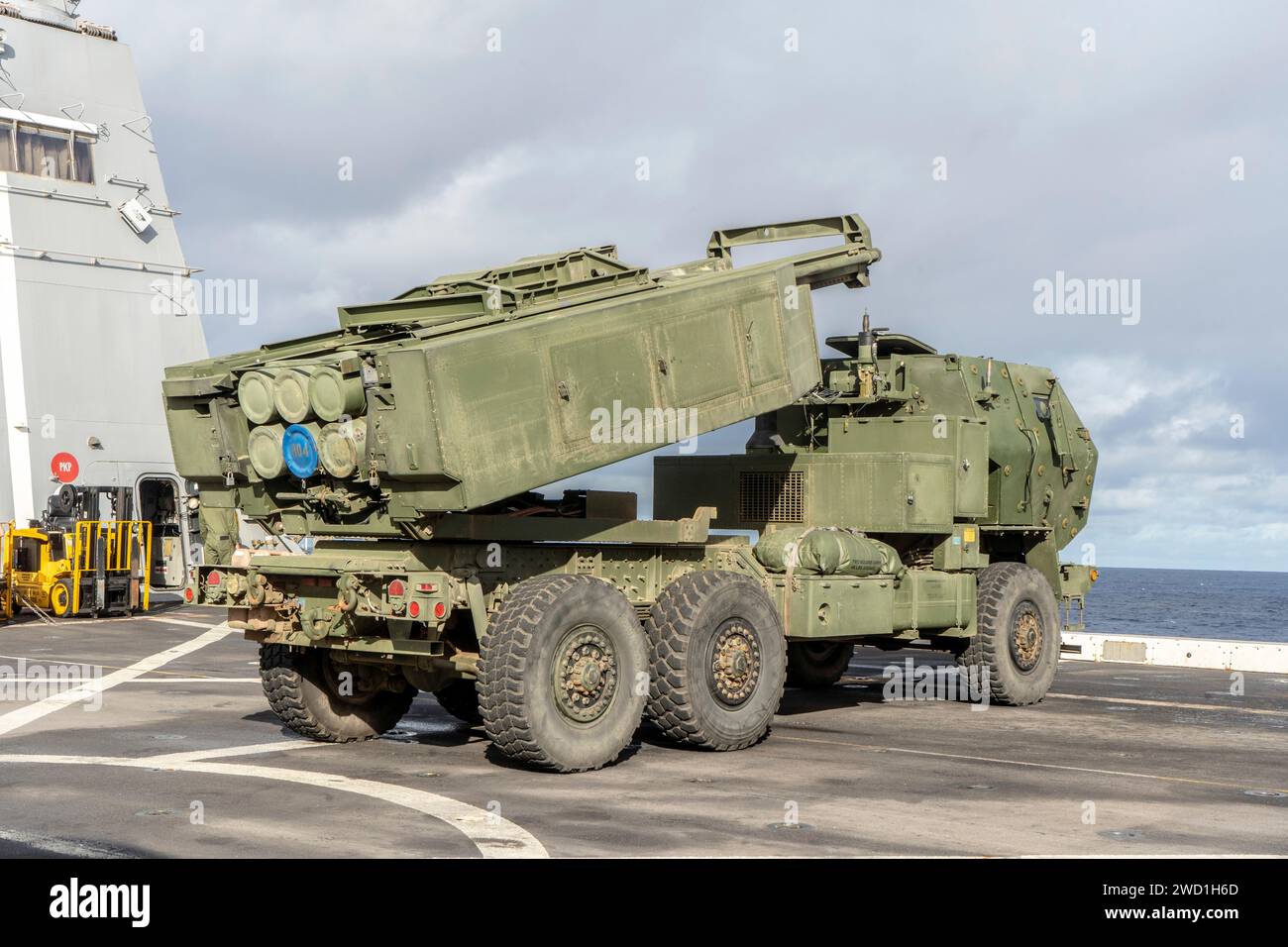 U.S. Marines position a HIMARS vehicle on the flight deck of a ship. Stock Photo
