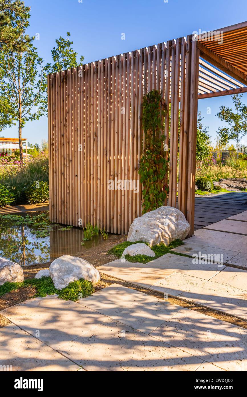 Modern wooden arbor. Modern wooden gazebo in courtyard, backyard. Urban gazebo, relaxing garden design. Stock Photo