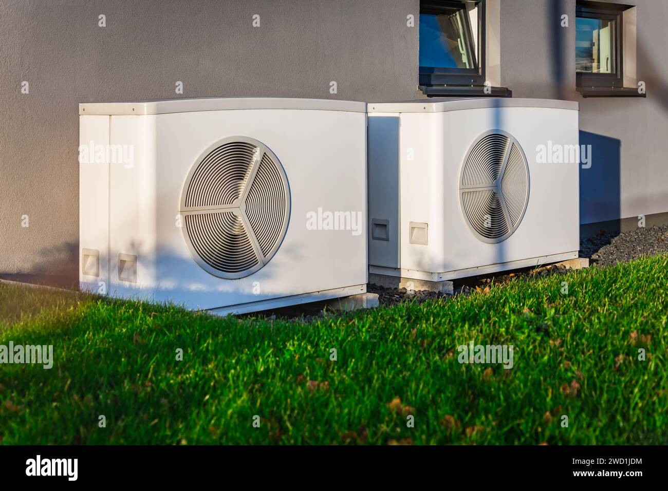 Two air source heat pumps installed outside of a modern house Stock
