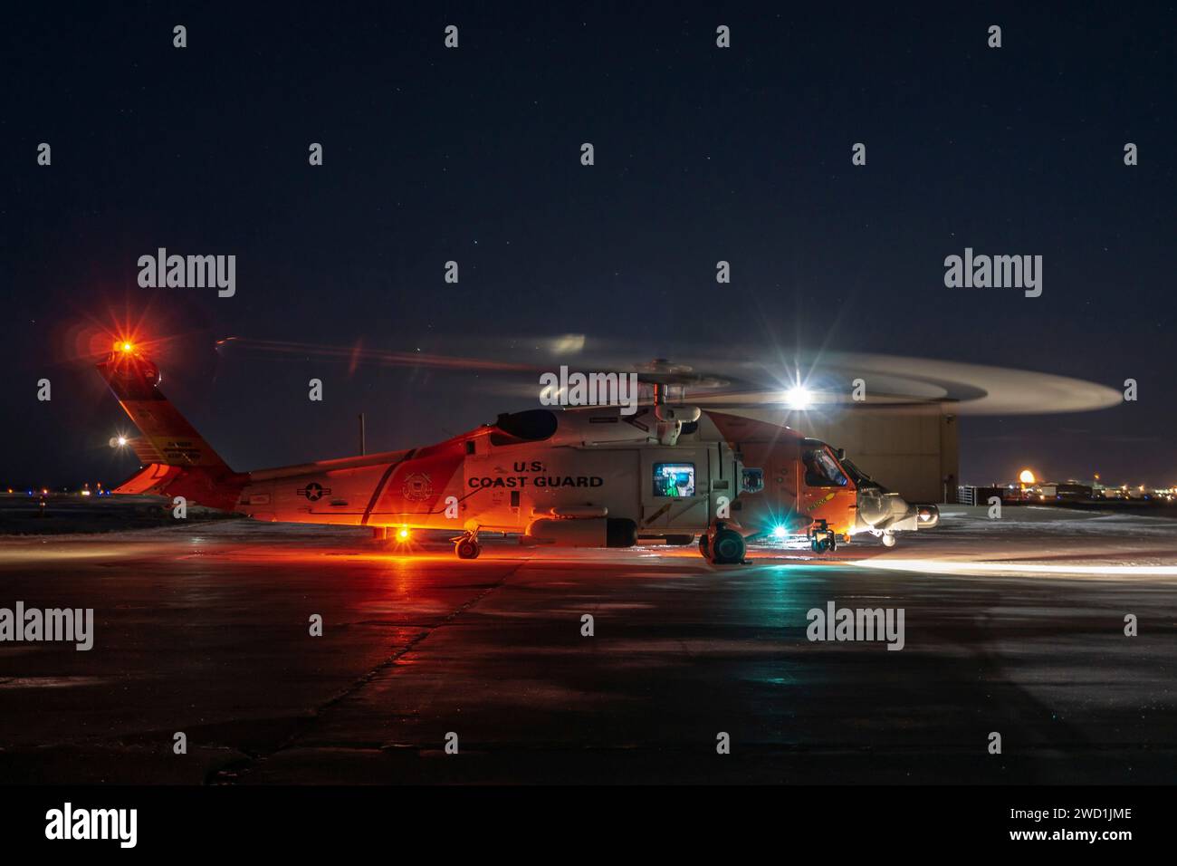A Coast Guard Air Station Kodiak aircrew prepares to take off to conduct a night flight. Stock Photo