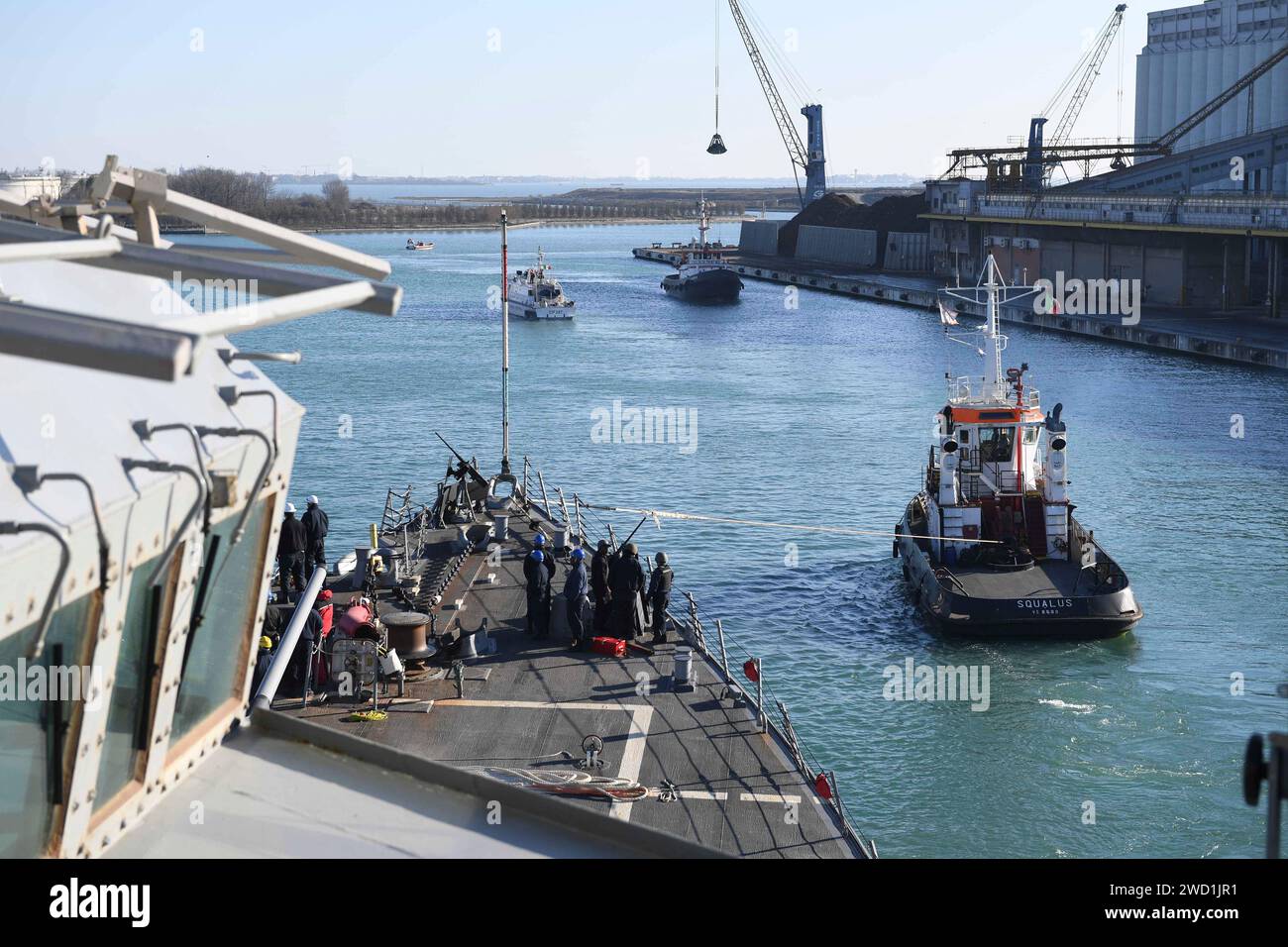 Guided missile destroyer USS Porter is pulled by a tugboat as it departs Venice, Italy. Stock Photo