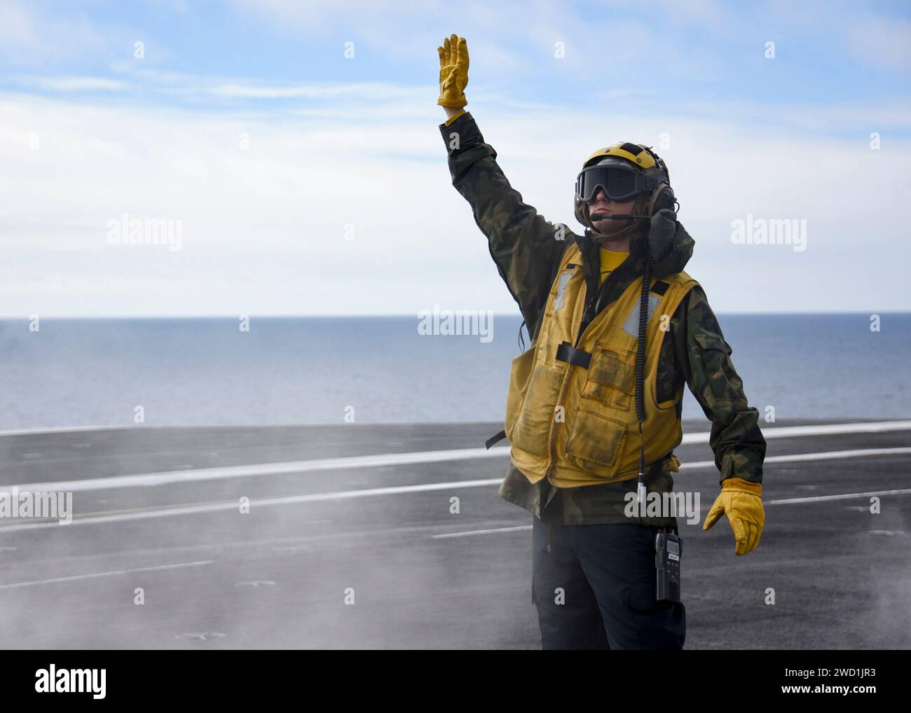 Aviation Boatswains Mate directs the crew of an E-2C Hawkeye on the ...