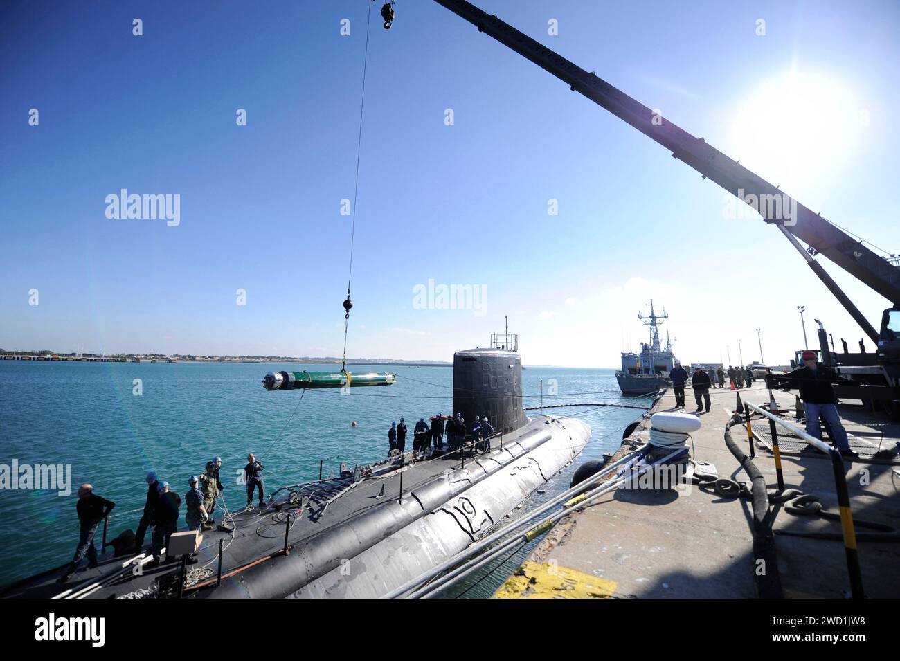 An MK-48 inert training torpedo is guided into the weapon loading skid of attack submarine USS California. Stock Photo