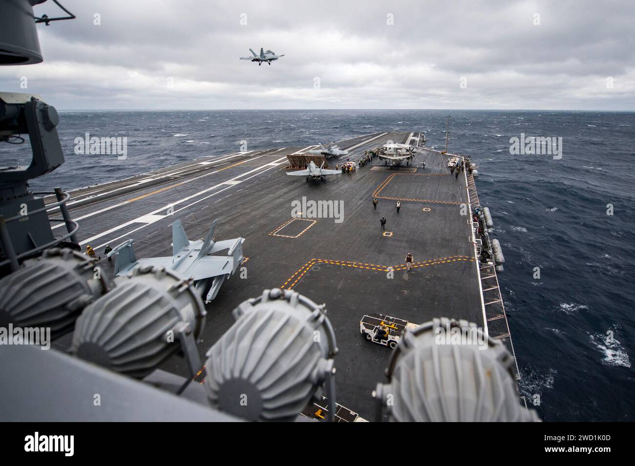 An E/A-18G Growler flies over the aircraft carrier USS George H.W. Bush. Stock Photo