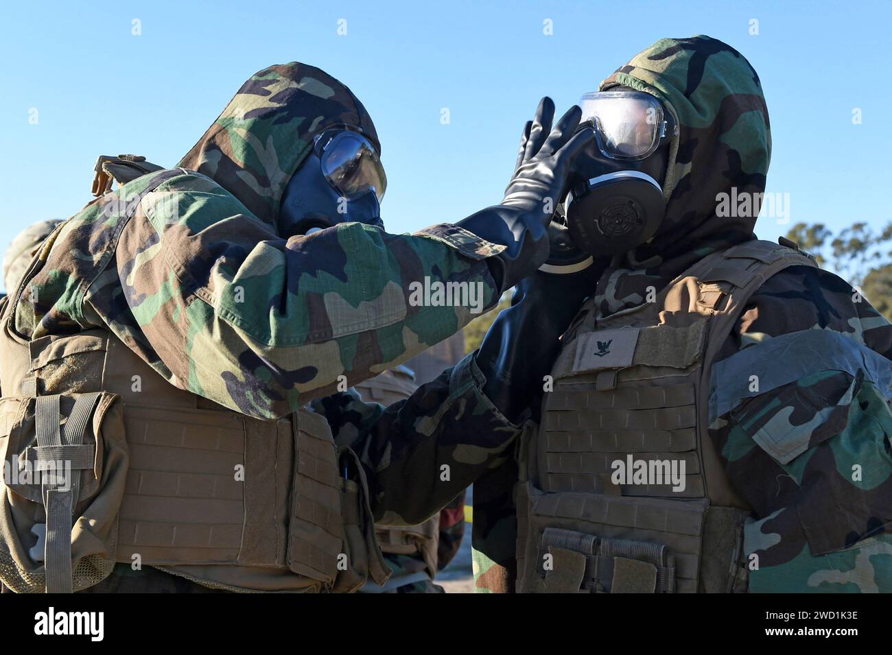 Seabees check to ensure they have properly donned their chemical, biological and radiological gear. Stock Photo