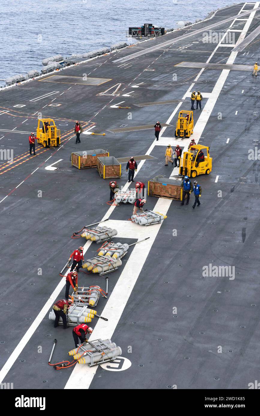 Sailors move ordnance on the flight deck of the aircraft carrier USS