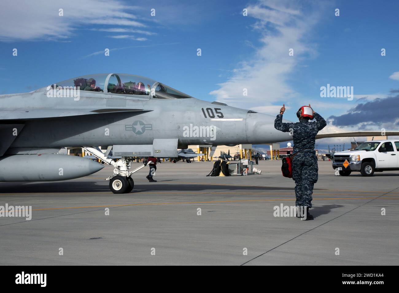 Sailor signals the crew of an F/A-18F Super Hornet. Stock Photo