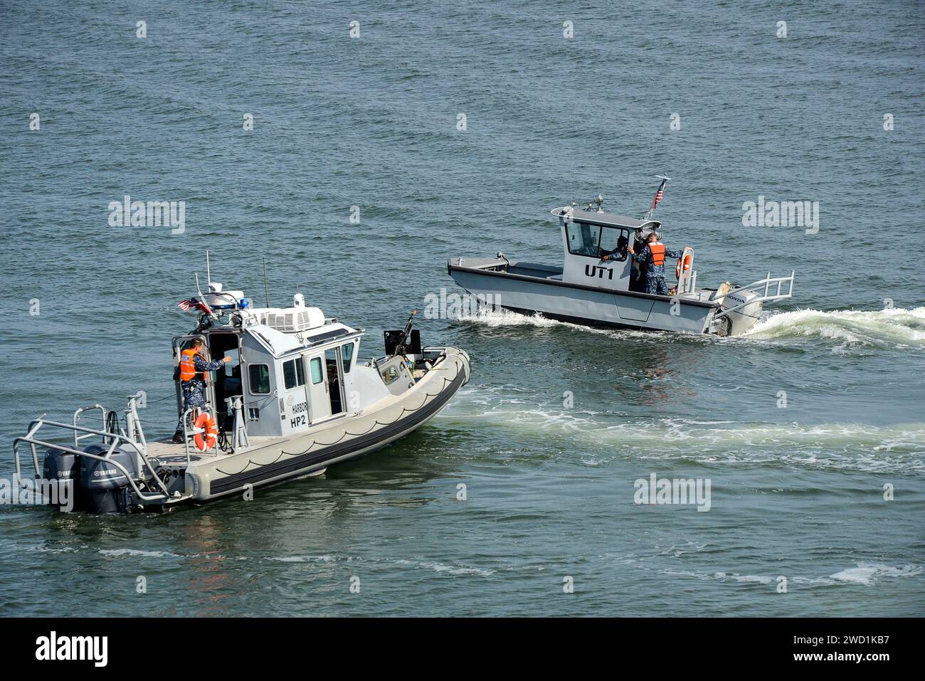 Small boats approach the amphibious assault ship USS Iwo Jima Stock