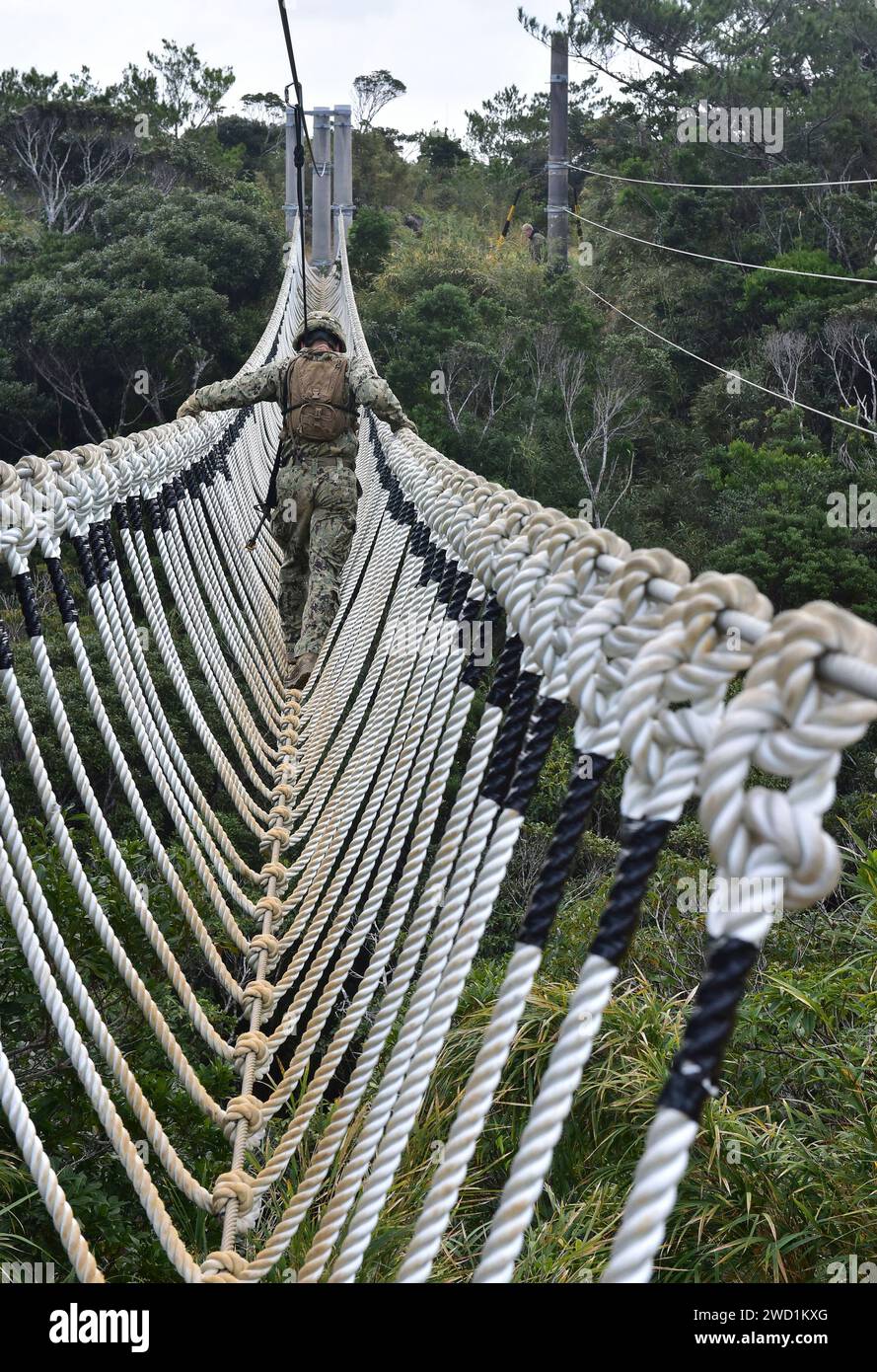 Soldier walks across a rope bridge at the Jungle Warfare Training Center, Camp Gonsalves, Okinawa, Japan. Stock Photo