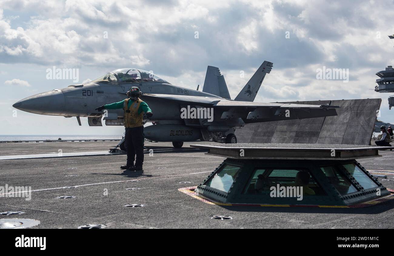 An F/A-18F Super Hornet is prepared for launch aboard the aircraft carrier USS George H.W. Bush. Stock Photo