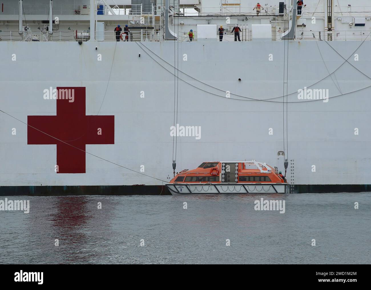 Civil service mariners lower the tender off USNS Comfort into the water. Stock Photo