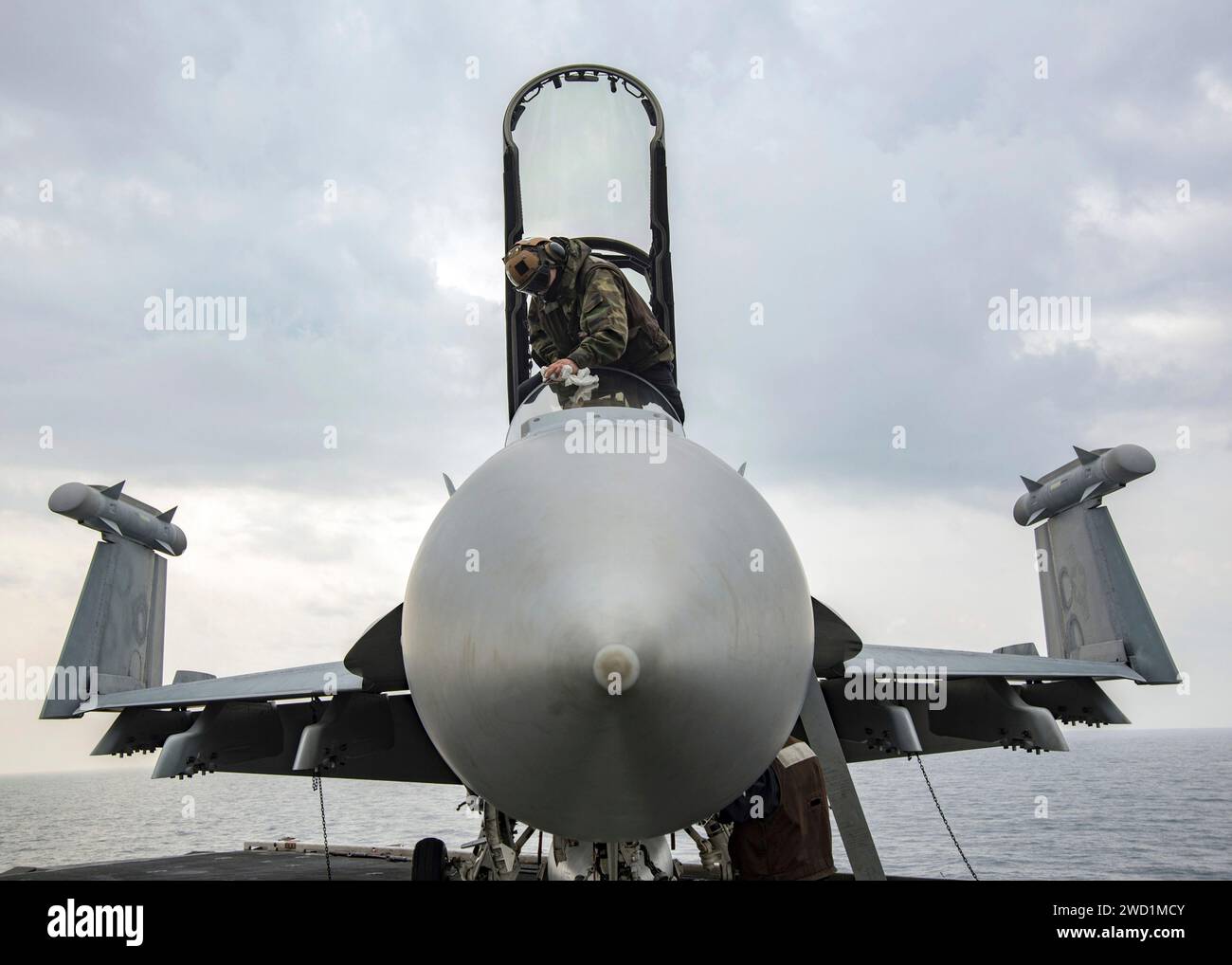 Airman wipes down an EA-18G Growler aircraft. Stock Photo
