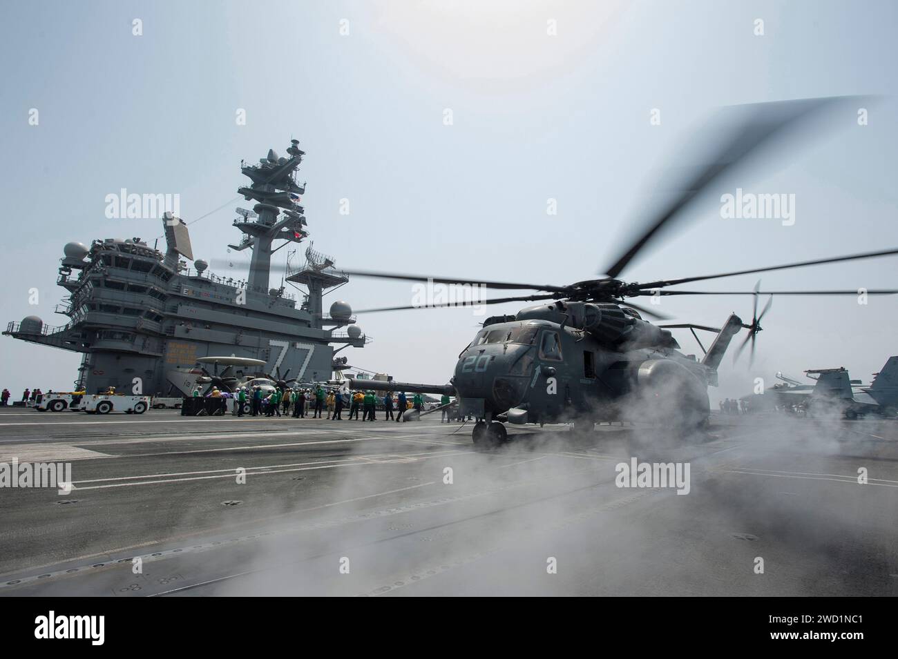 Sailors unload mail from an MH-53E Sea Dragon helicopter aboard USS George H.W. Bush. Stock Photo