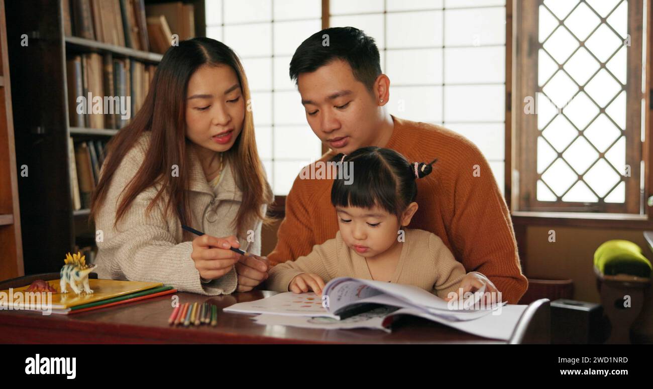 Japanese family, education and learning for school with homework in living room of apartment