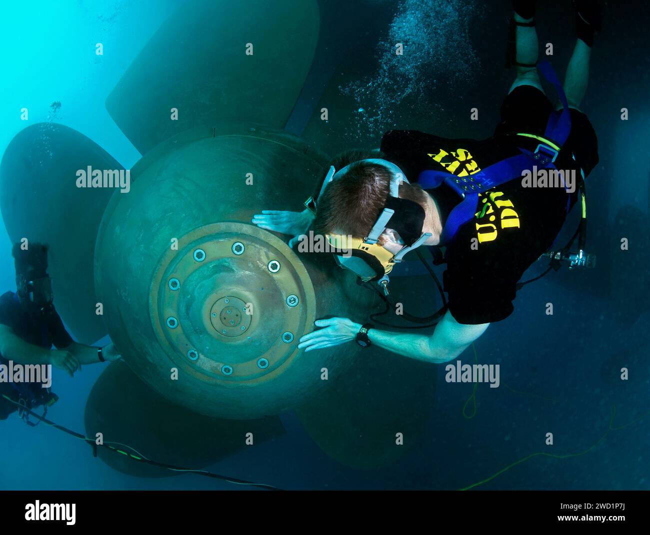 U.S. Navy divers conduct a propeller inspection on USS Hue City. Stock Photo