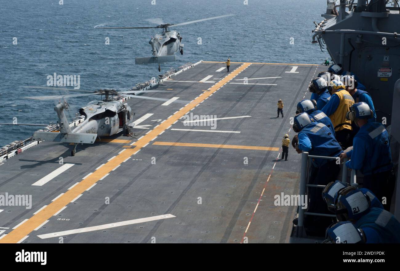 Two MH-60S Sea Hawk helicopters take off from the amphibious assault ship USS Wasp. Stock Photo