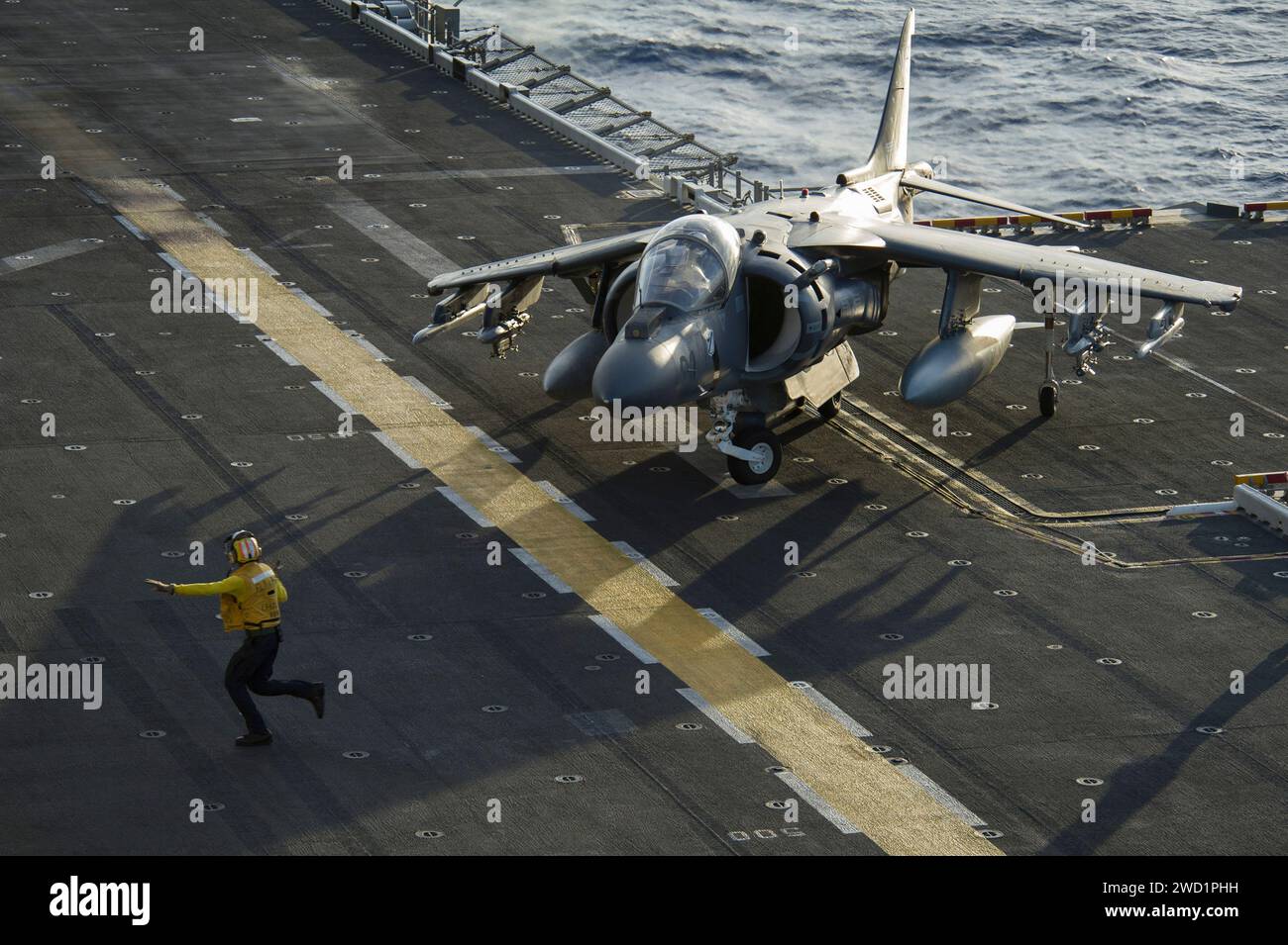 Aviation Boatswain's Mate directs an AV-8B Harrier on the flight deck of USS America. Stock Photo