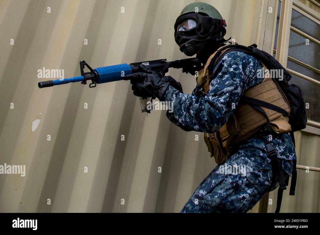 A U.S. Naval ROTC Midshipman provides security while training in an urbanized terrain facility. Stock Photo