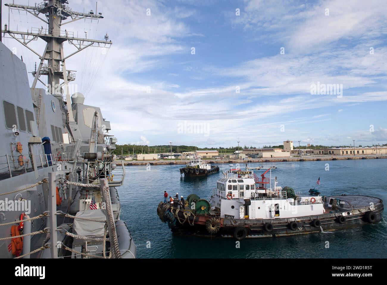 Harbor tugboats approach the Arleigh Burke-class guided-missile destroyer USS Sterett. Stock Photo