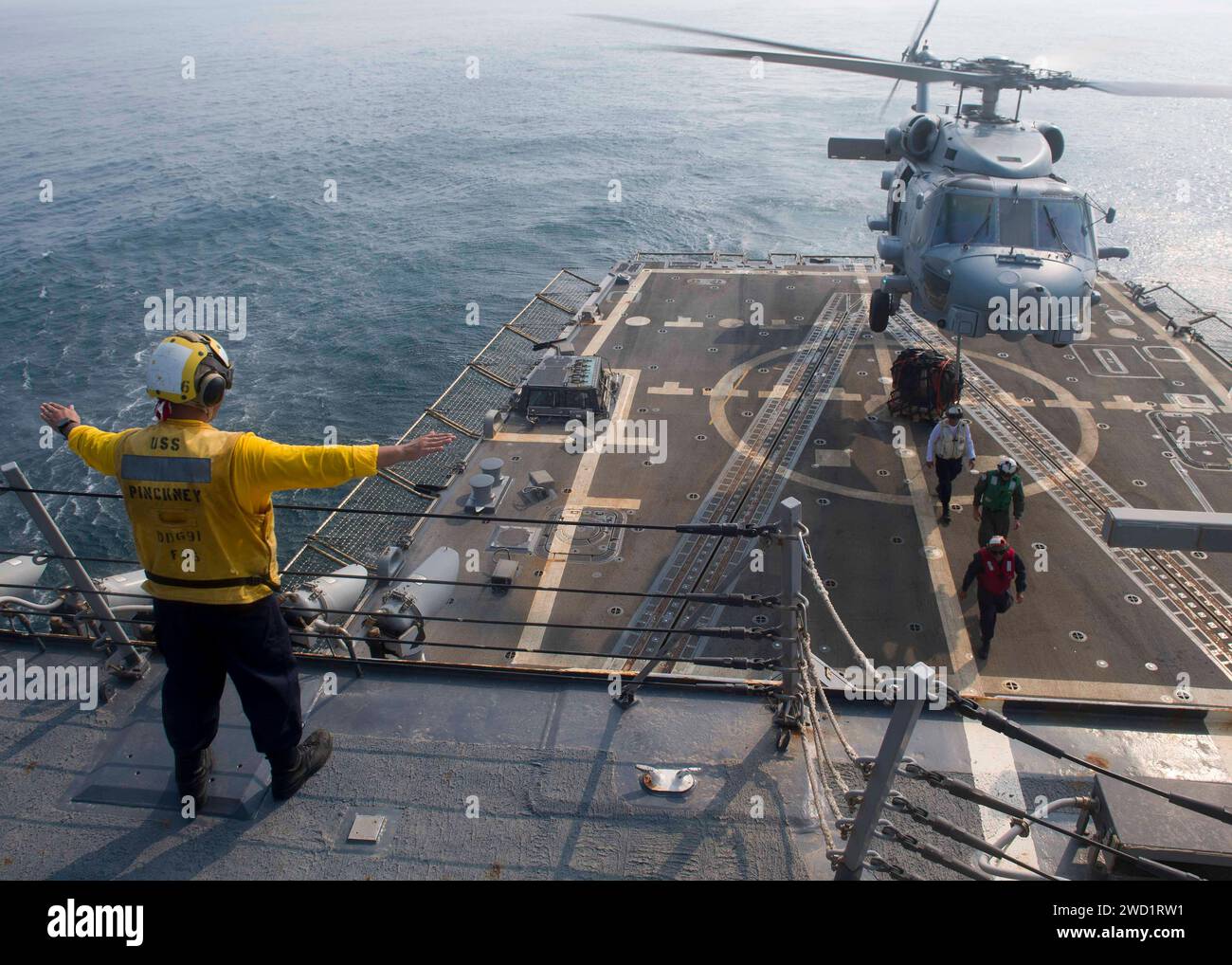 An MH-60R Sea Hawk helicopter conducts vertical replenishment training with USS Pinckney. Stock Photo