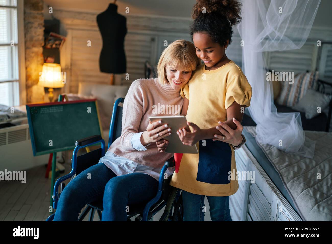 Little african american girl and her single mother in wheelchair spending quality time together. Stock Photo