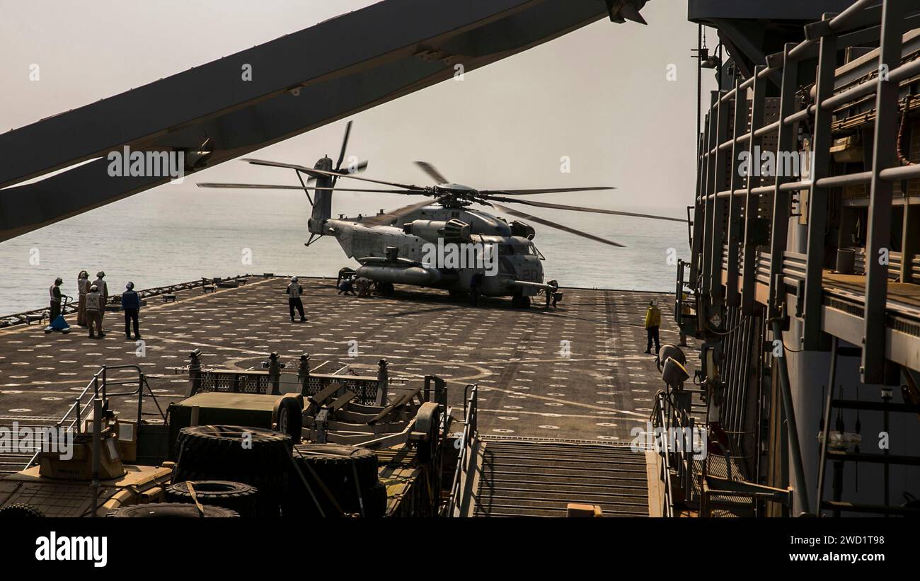 A CH-53E Super Stallion helicopter prepares to depart the amphibious dock landing ship USS Pearl Harbor. Stock Photo