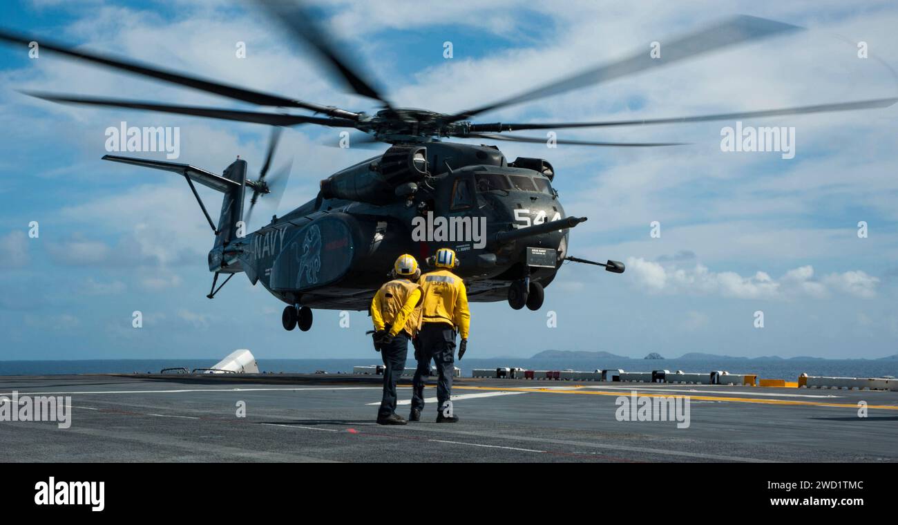 An MH-53E Sea Dragon helicopter lands aboard the amphibious assault ...