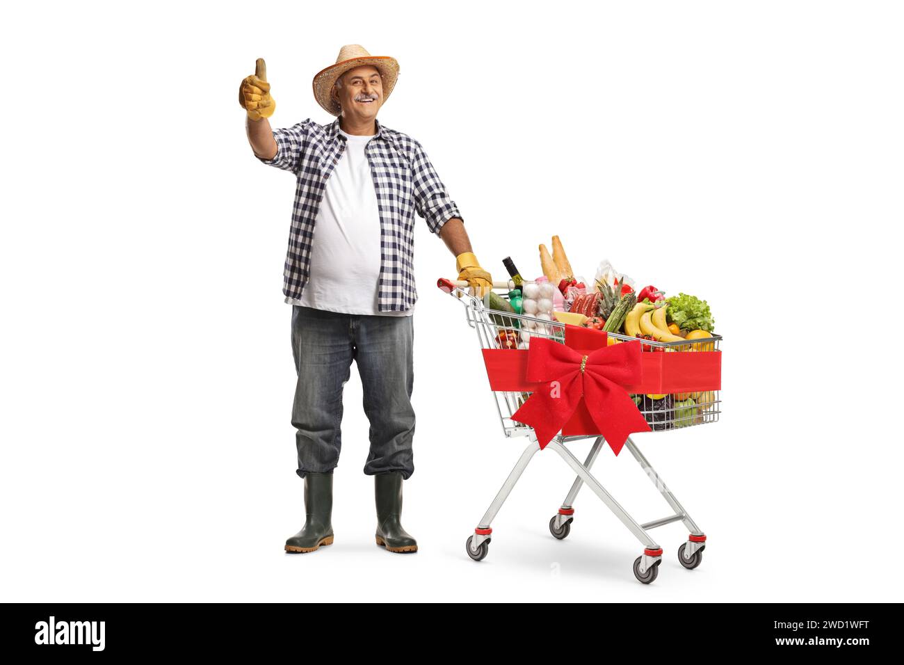 Full length portrait of a farmer with a shopping cart full of food products waving isolated on white background Stock Photo