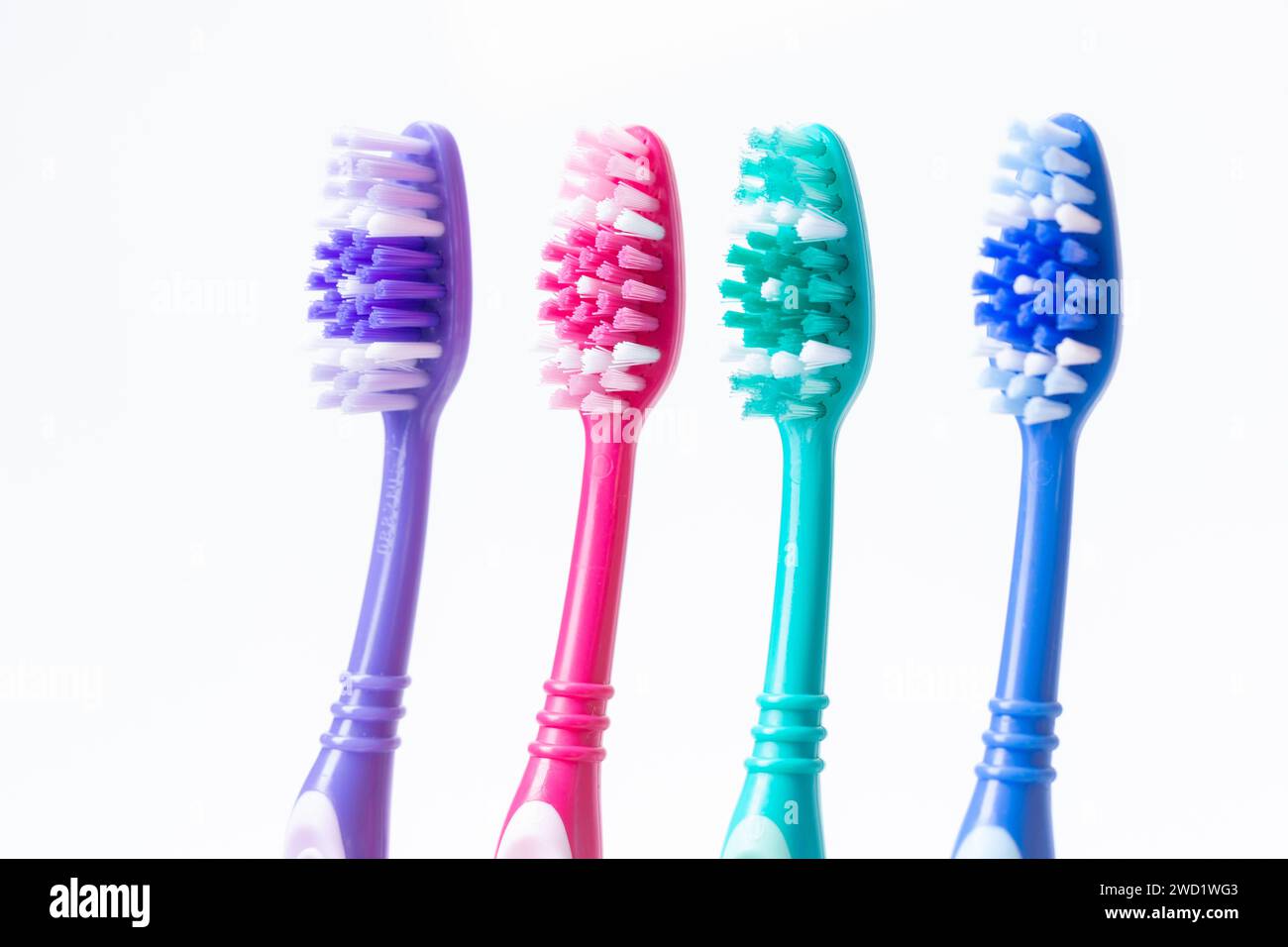 Four colourful plastic toothbrushes Stock Photo