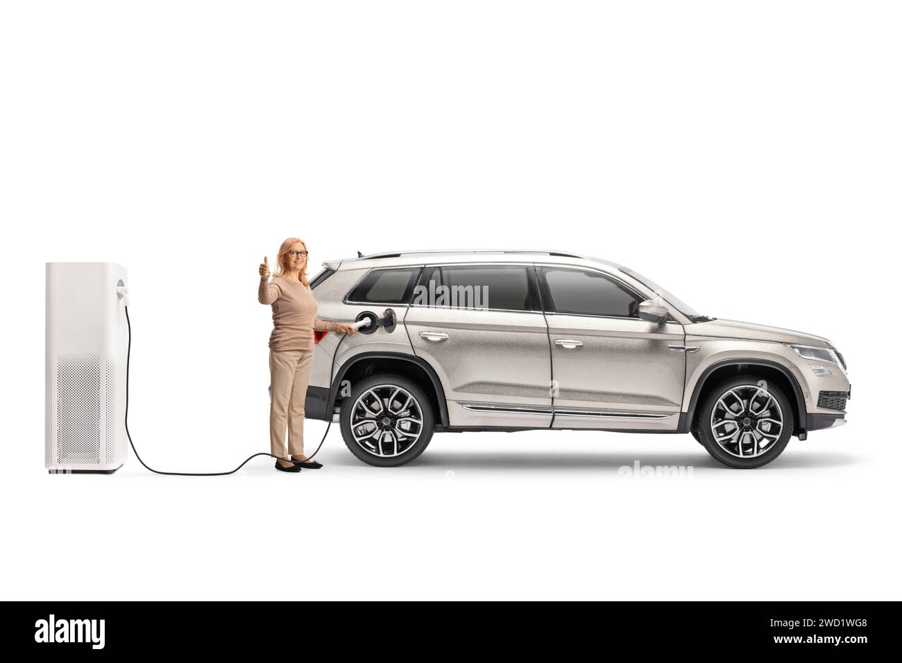 Woman charging an electric vehicle at a charging point and gesturing thumbs up isolated on white background Stock Photo