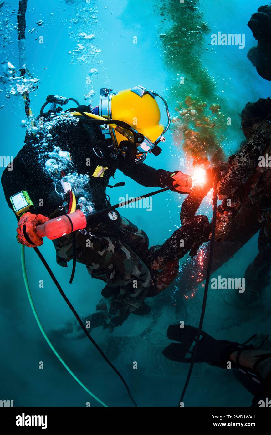 U.S. Navy Diver performs underwater cutting operations using a Broco torch. Stock Photo