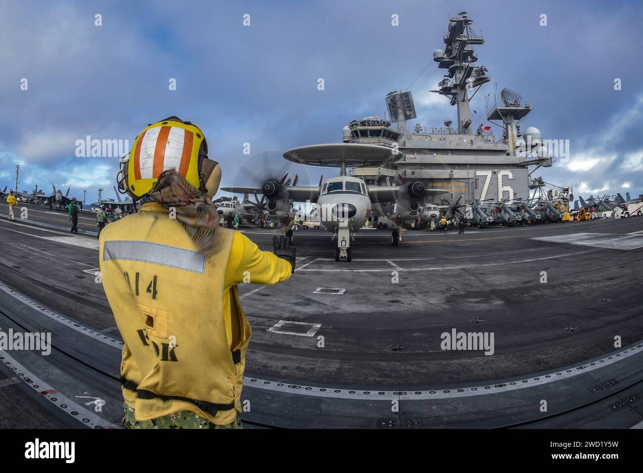 Aviation Boatswain's Mate signals an E-2D Hawkeye to move on flight deck of the USS Ronald Reagan. Stock Photo