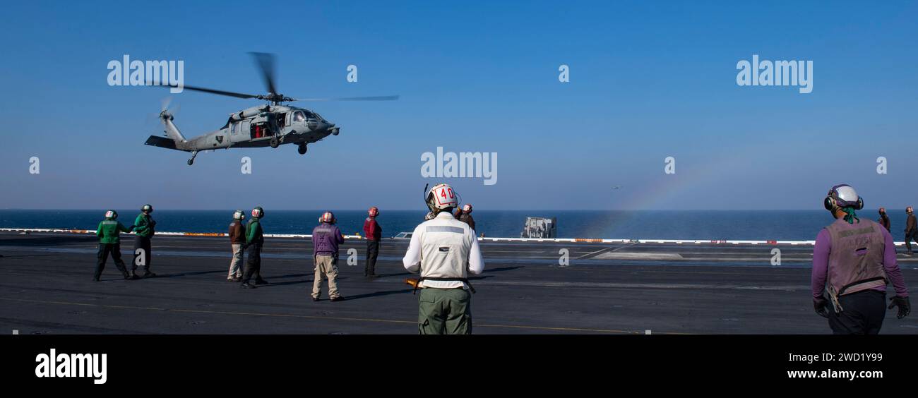 An MH-60S Sea Hawk helicopter lands on the flight deck of USS Nimitz. Stock Photo