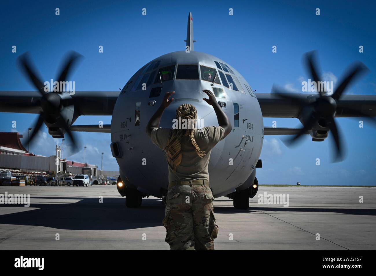 U.S. Air Force specialist marshals a C-130J Super Hercules. Stock Photo