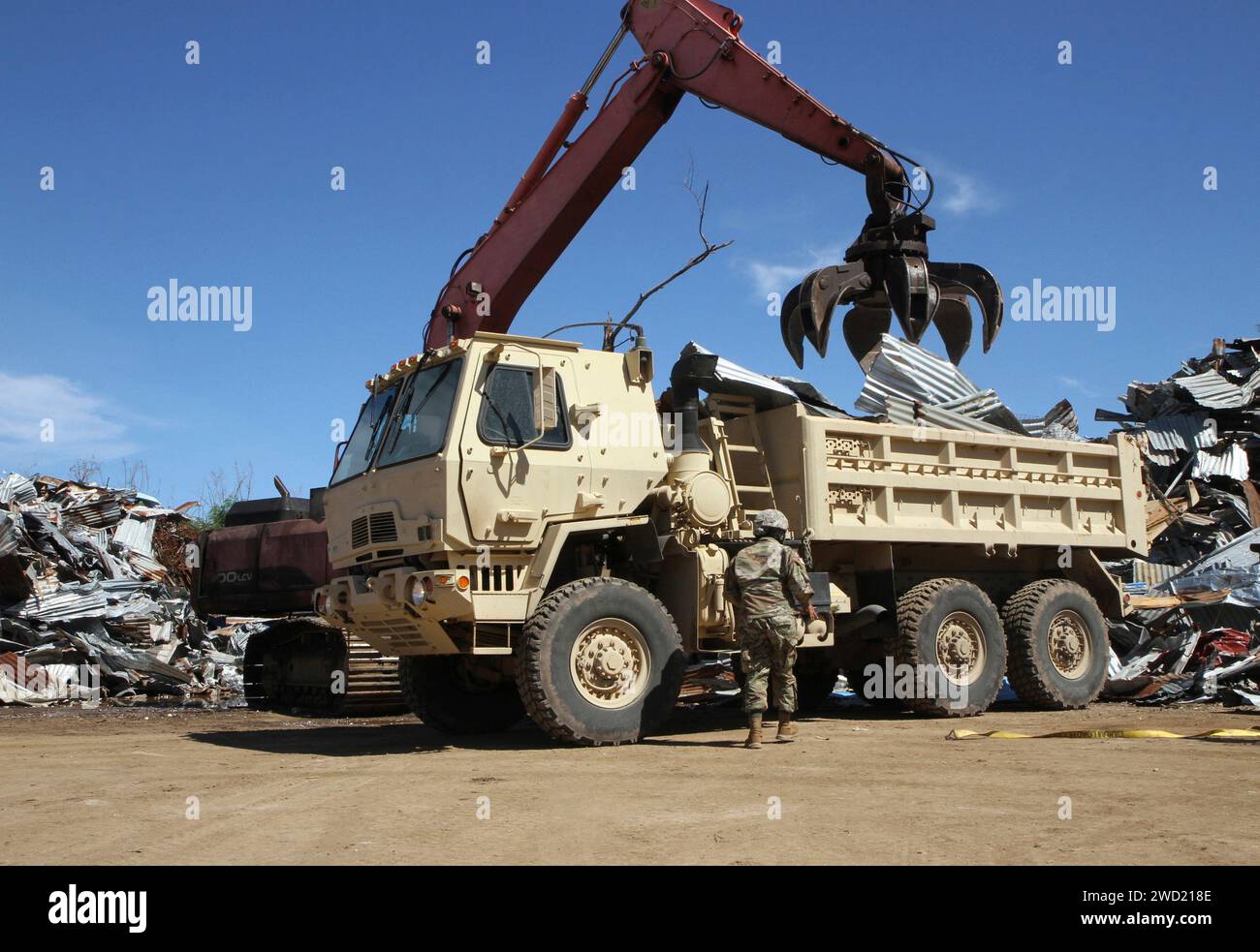 A U.S. Soldier with the Guam Army National Guard releases tie straps from a military tactical vehicle. Stock Photo