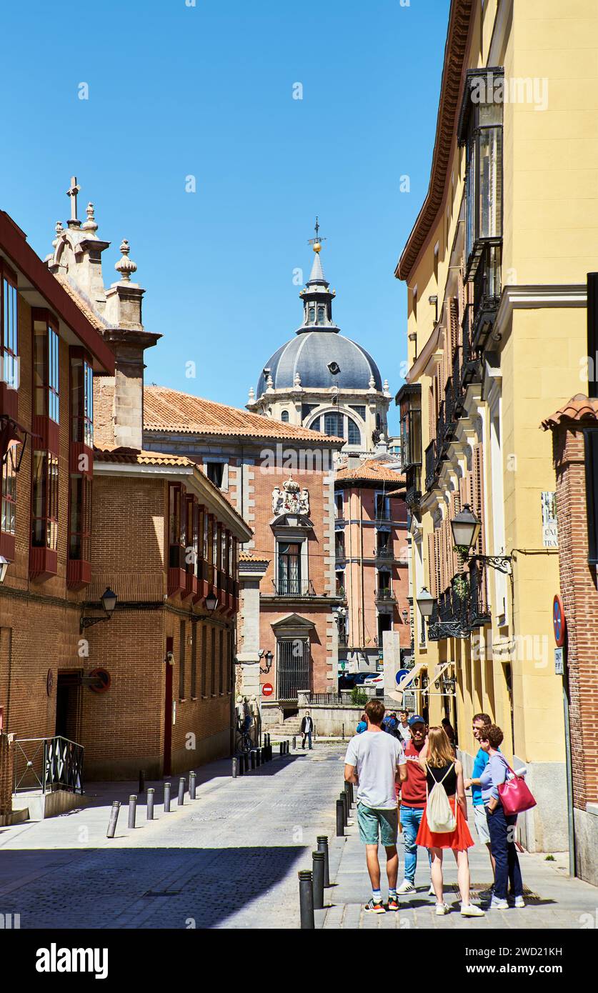 View of Calle Sacramento on a sunny day with the Church of the Armed Forces (Iglesia Fuerzas Armadas) as people or tourists walk on the street. Madrid Stock Photo