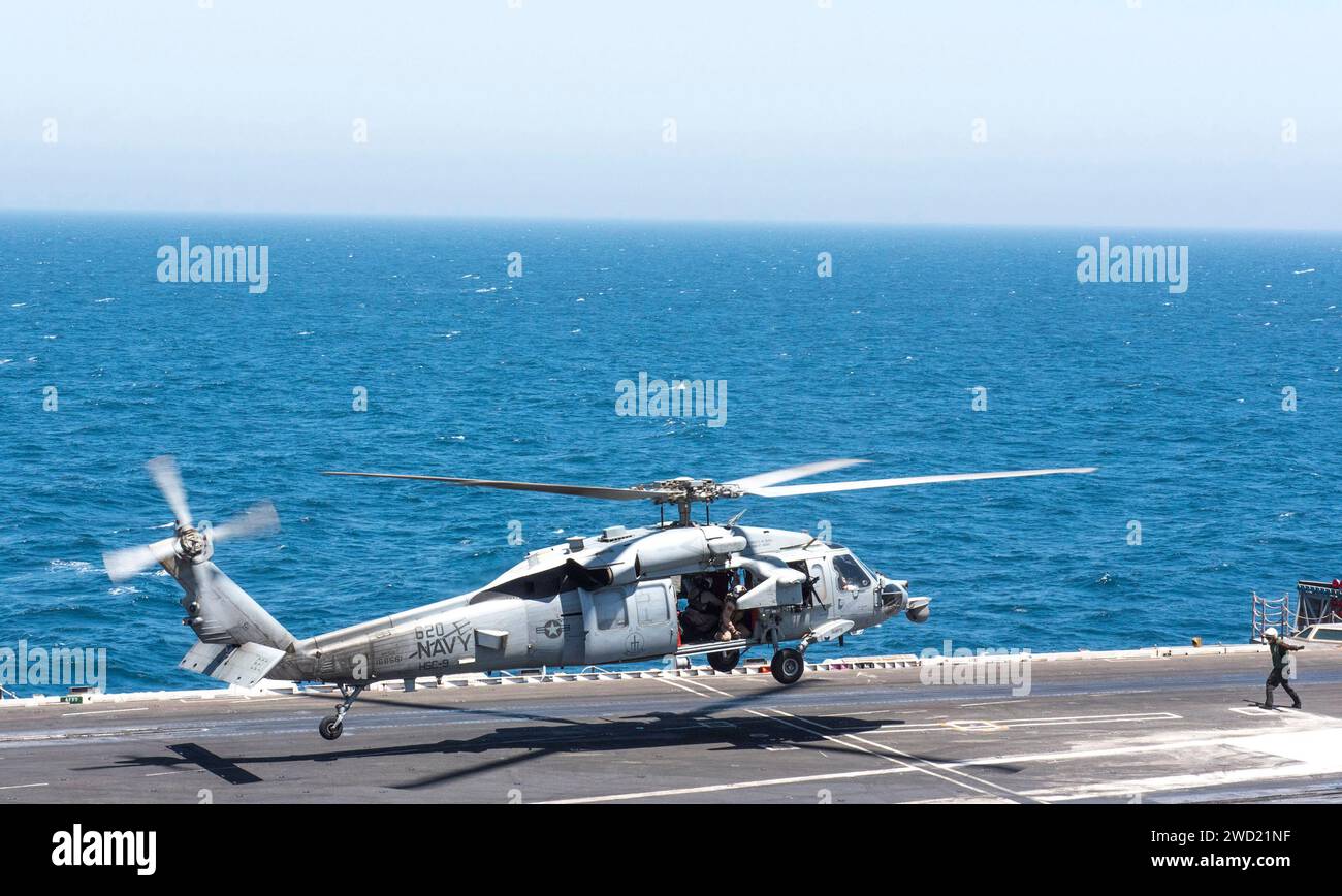 An MH-60S Sea Hawk helicopter lands on the flight deck of USS George H.W. Bush. Stock Photo