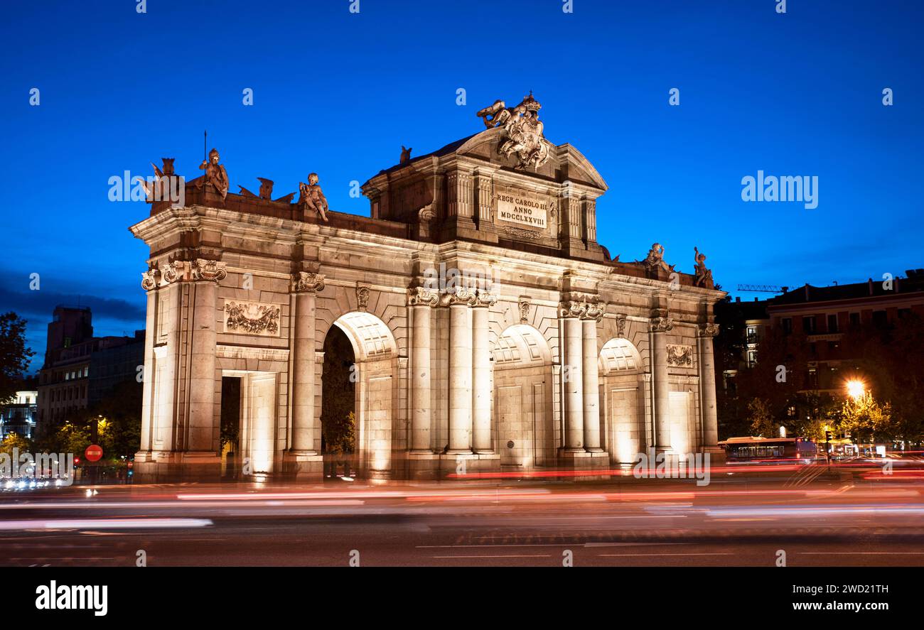 Puerta de Alcalá by the entrance of El Retiro park at blue hour in Madrid. Puerta Alcala evening view with car light trails as the night approaches Stock Photo