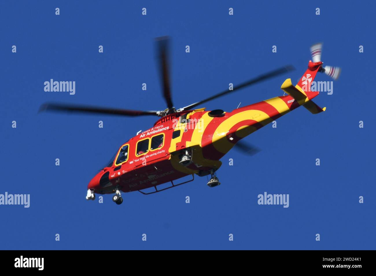 An Essex & Herts Air Ambulance flying over the Thames before preparing to land in Tilbury. Stock Photo