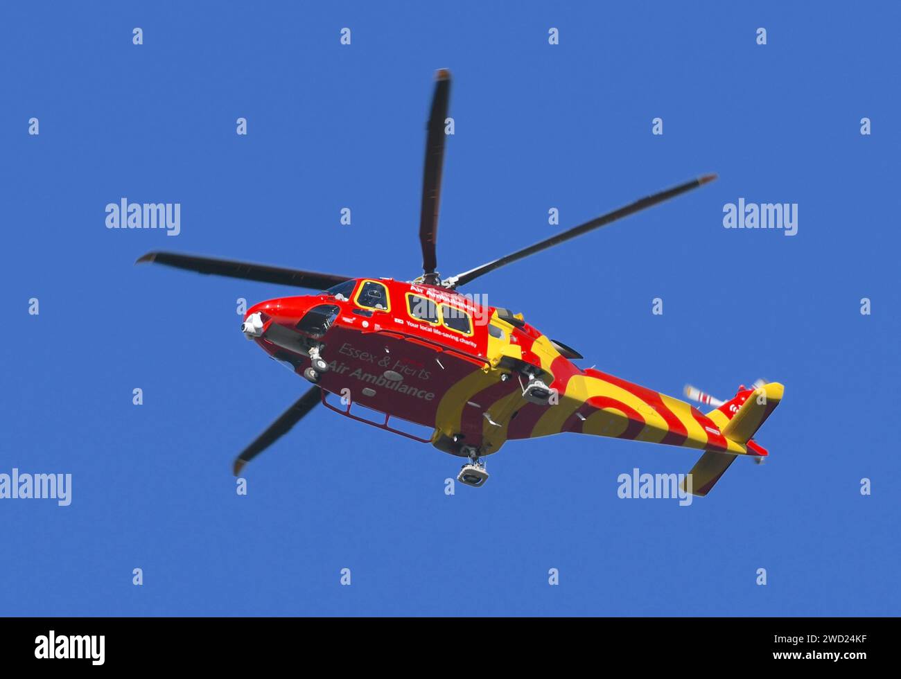 An Essex & Herts Air Ambulance flying over the Thames before preparing to land in Tilbury. Stock Photo