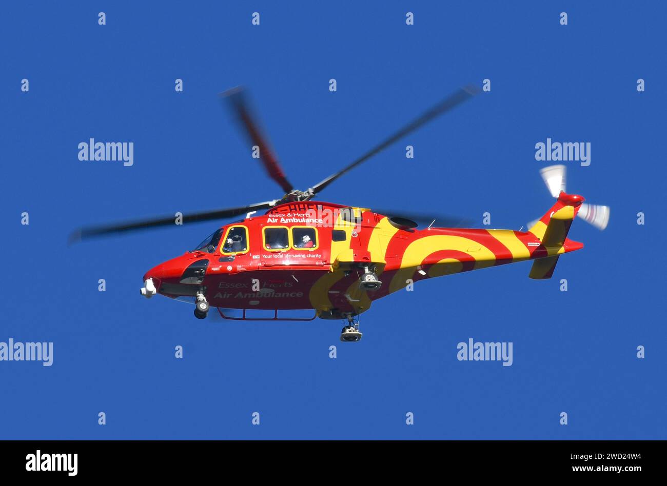 An Essex & Herts Air Ambulance flying over the Thames before preparing to land in Tilbury. Stock Photo