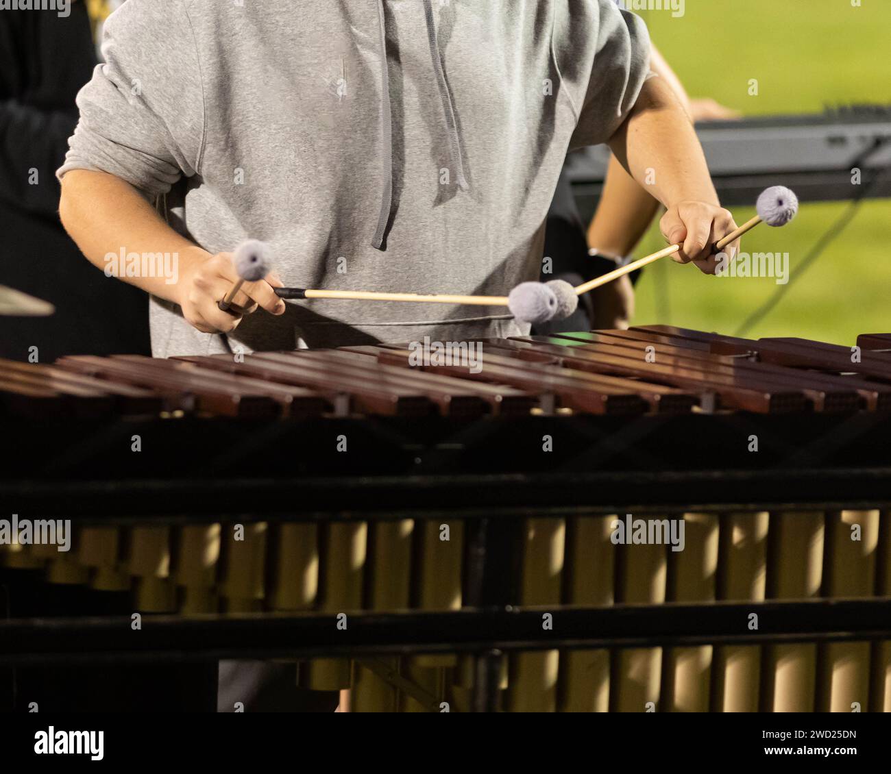 flashing mallets of the sideline percussionists at rehearsal Stock Photo