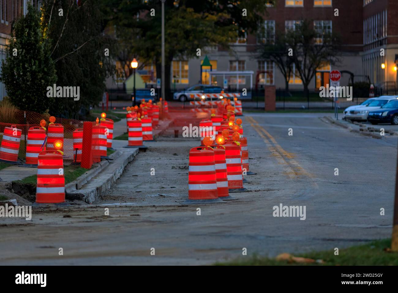 several orange barrels and traffic cones protecting a road repair Stock Photo