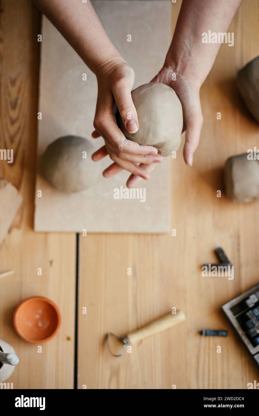 Ceramist Slapping a damp lump of clay with his hands Stock Photo
