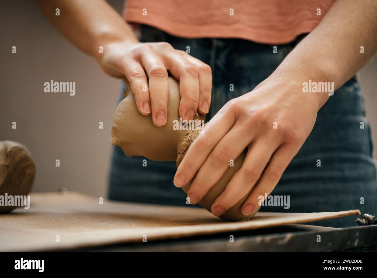 Cramists hands tear, divide soft, raw white clay into pieces Stock Photo