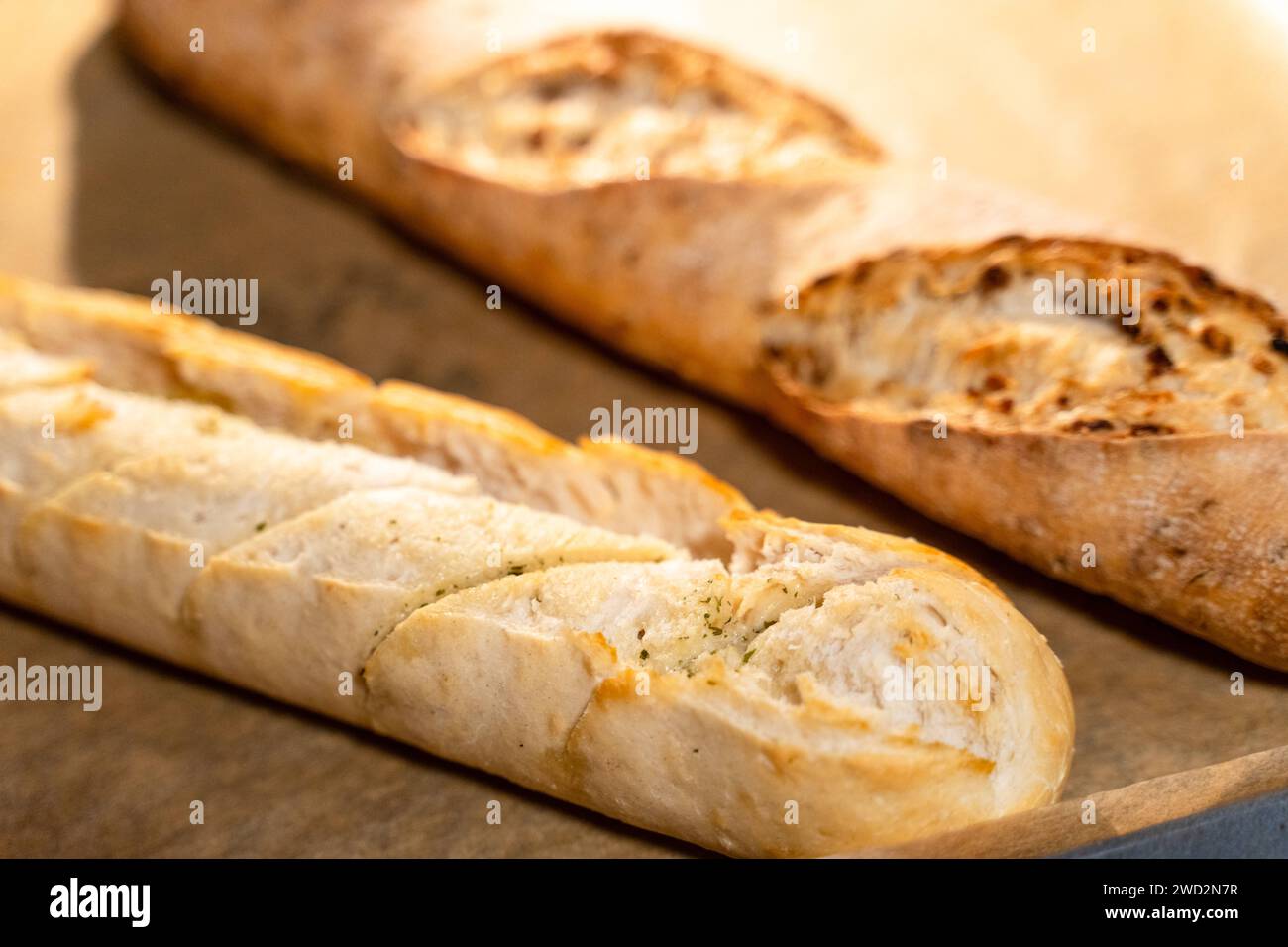 December 24, 2023: Baguette and herb baguette in an oven on baking ...