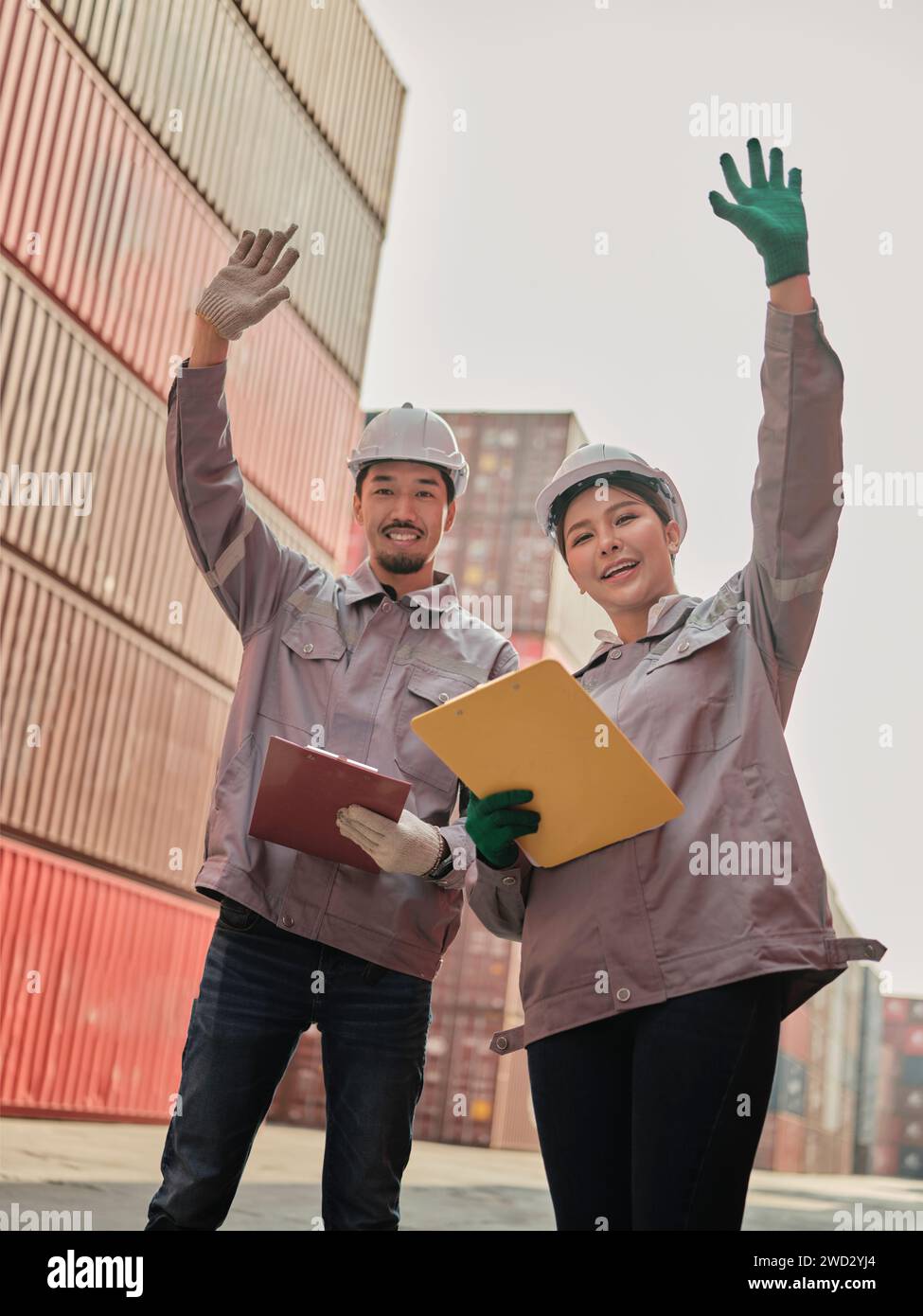 A team of engineers waving hand to say hello, greeting someone at the Container cargo . Quality inspection, work plan,  industrial building design pro Stock Photo