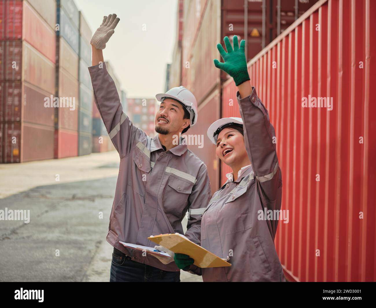 A team of engineers waving hand to say hello, greeting someone at the Container cargo . Quality inspection, work plan,  industrial building design pro Stock Photo