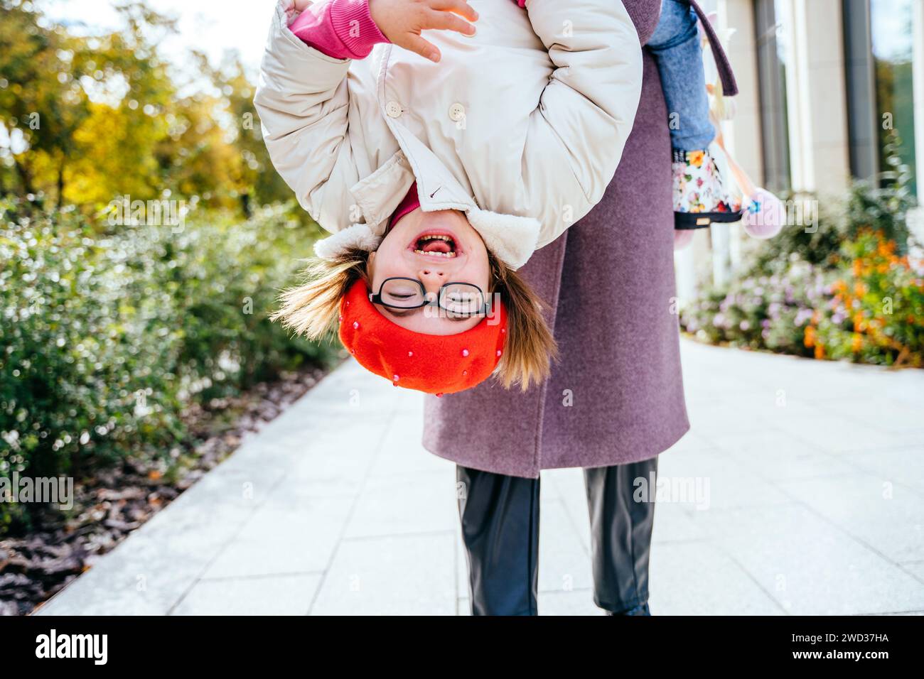 Brunette mom and cute little daughter upside down. Stock Photo