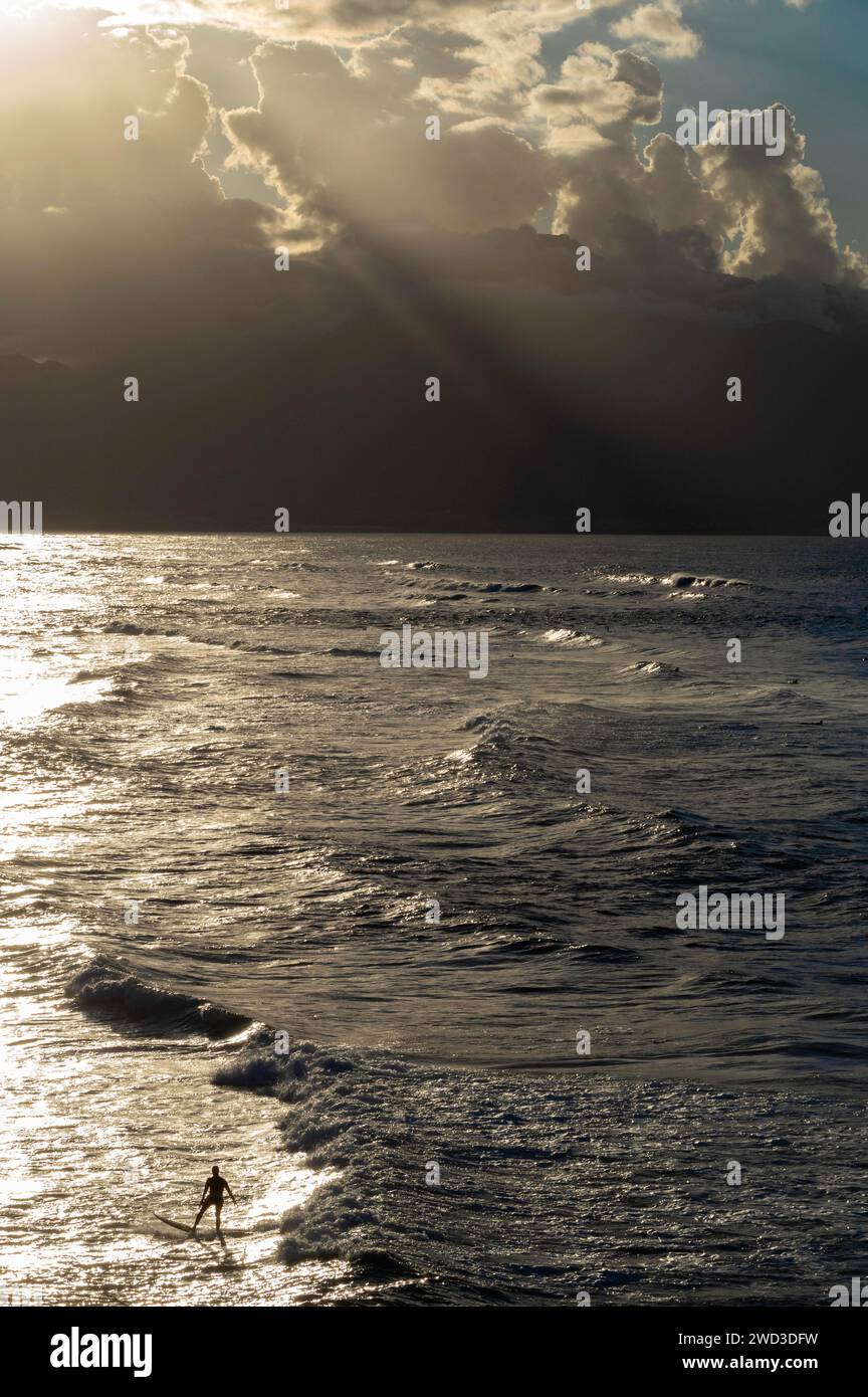 Surfing at Hookipa Beach Park as the sun sets over the West Maui